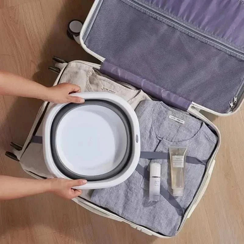 Portable plastic folding basin in a suitcase, ideal for travel and space-saving storage.