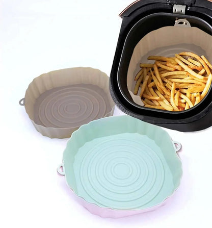Silicone air fryer liners with side handles in various colors, shown alongside an air fryer basket with fries.