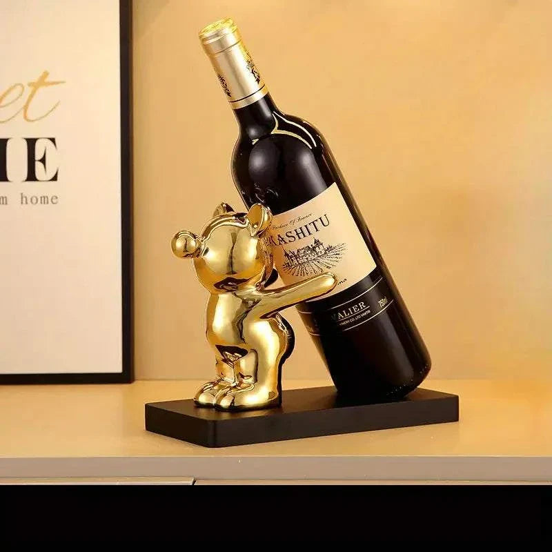 Ceramic bear wine rack with gold finish, holding a wine bottle, for home and kitchen decor.