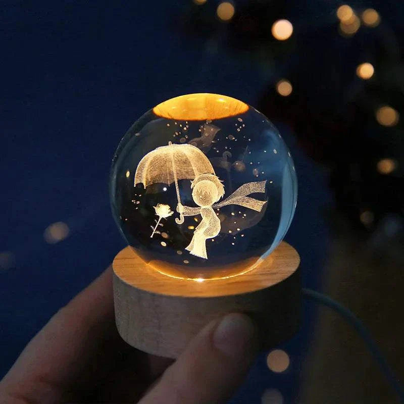 6cm 3D crystal ball with laser-engraved solar system, glowing on a wooden base.